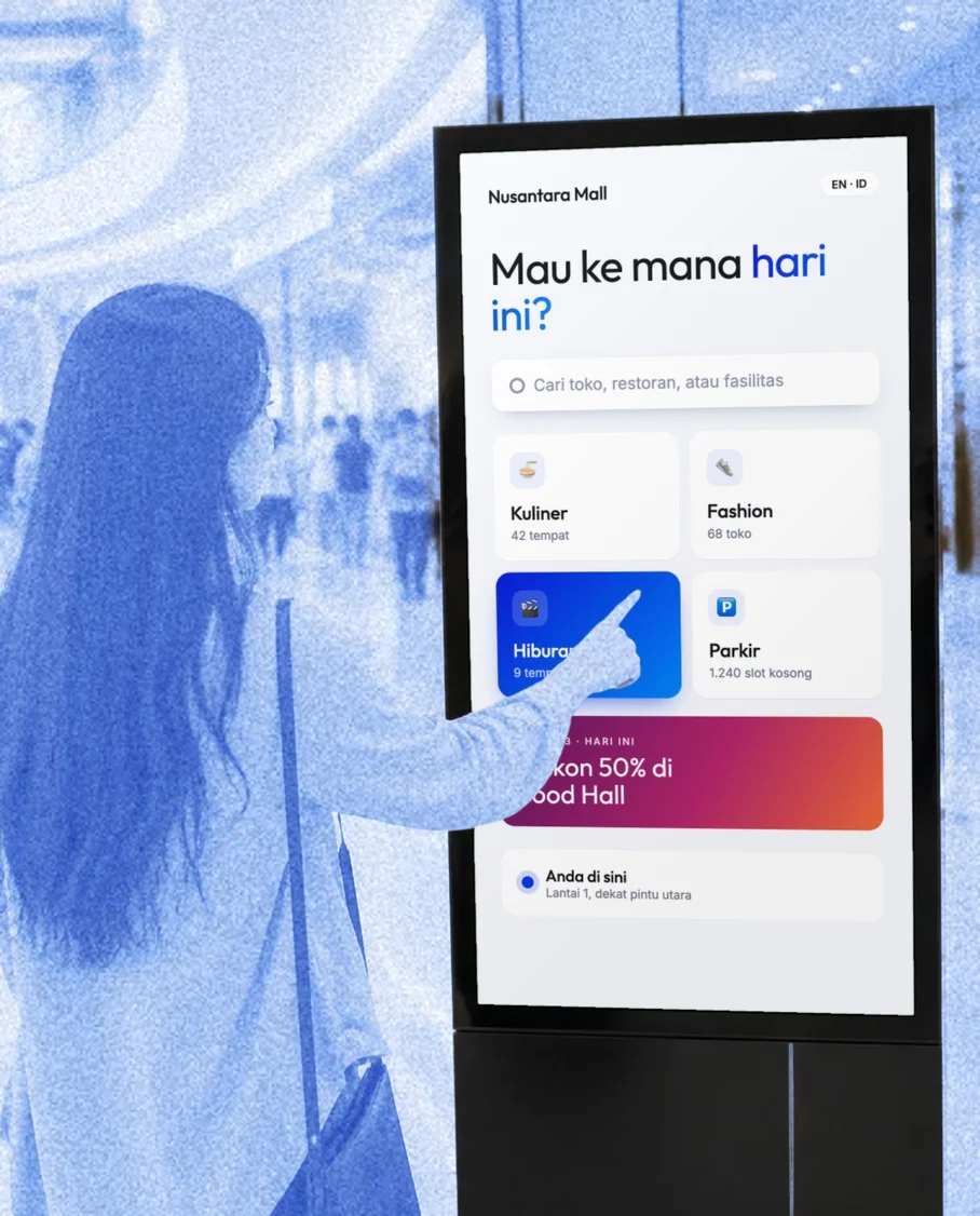 Pengunjung menyentuh situs direktori mal di layar sentuh Marien